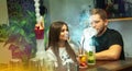 Happy couple smokes shisha and drink cocktails