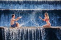 Happy couple splashing with fun in waterfall pool Royalty Free Stock Photo