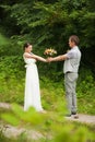 Happy couple standing in green park, kissing, smiling, laughing Royalty Free Stock Photo