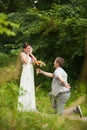 Happy couple standing in green park, kissing, smiling, laughing Royalty Free Stock Photo