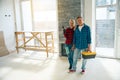 Happy couple standing and holding construction tools in hands Royalty Free Stock Photo
