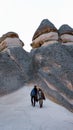 Happy couple standing near cave houses surrounded by fairy chimneys at Pasabag Valley in Turkey Royalty Free Stock Photo