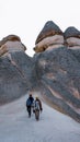 Happy couple standing near cave houses surrounded by fairy chimneys at Pasabag Valley in Turkey Royalty Free Stock Photo