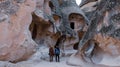 Happy couple standing near cave houses surrounded by fairy chimneys at Pasabag Valley in Turkey Royalty Free Stock Photo