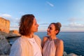 Happy couple standing on rocky cliff at sunset Royalty Free Stock Photo