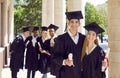 Happy couple students in graduation dresses and hats enjoy graduation ceremony together. Royalty Free Stock Photo