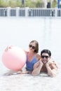 Happy couple and summer vacations at resort. Male and female playing in the pool with a beach ball. Couple looking to camera Royalty Free Stock Photo