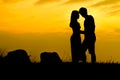 Happy couple on Sunset rock - Silhouette