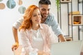 Young man and ginger woman have fun shopping online together on computer. Royalty Free Stock Photo