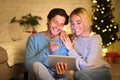 Happy couple surfing net on tablet enjoying christmas atmosphere Royalty Free Stock Photo