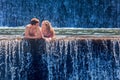 Happy couple swimming in natural spring waterfall pool Royalty Free Stock Photo