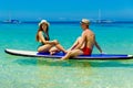 A happy couple in swimsuits have fun on a paddleboard in the tropical sea. The concept of travel and family holidays