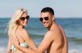 Happy couple in swimwear sitting on summer beach Royalty Free Stock Photo