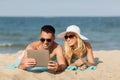 Happy couple with tablet pc sunbathing on beach Royalty Free Stock Photo