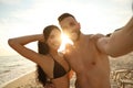 Happy couple taking selfie on beach at sunset Royalty Free Stock Photo