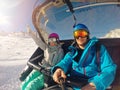 Happy couple taking selfie in chairlift at ski resort Royalty Free Stock Photo