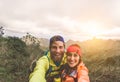 Happy couple taking selfie while doing trekking excursion on mountains - Young hikers having fun on exploration nature tour