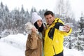 Happy couple taking selfie near forest. Winter vacation Royalty Free Stock Photo
