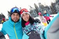 Happy couple taking selfie on snowy slope Royalty Free Stock Photo