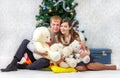 Happy couple with teddy bears near Christmas tree