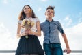 Happy couple of teens boy and girl 14, 15 years old. Young people smiling and talking, blue sky background Royalty Free Stock Photo