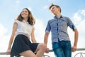 Happy couple of teens boy and girl 14, 15 years old. Young people smiling and talking, blue sky background Royalty Free Stock Photo