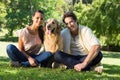 Happy couple with their pet dog in the park Royalty Free Stock Photo