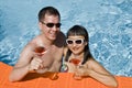 Happy Couple Toasting with Pink Martini in a Pool Royalty Free Stock Photo