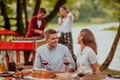 Happy couple toasting red wine glass while having picnic french dinner party outdoor during summer holiday vacation near Royalty Free Stock Photo