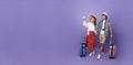 Happy couple tourist hand pointing to copy space with baggage going to travel on holidays isolated on purple background Royalty Free Stock Photo