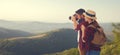 Happy couple tourist with photocamera at top of mountain at suns