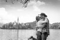 Happy couple of tourists in love is kissing on the background with Bled Lake and Church on the Island, Slovenia. Summer time in Royalty Free Stock Photo