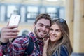 Happy couple of tourists taking selfie in showplace of city. Man and woman making photo on city background Royalty Free Stock Photo