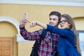 Happy couple of tourists taking selfie in showplace of city. Man and woman making photo on city background Royalty Free Stock Photo