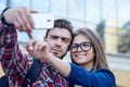 Happy couple of tourists taking selfie in showplace of city. Man and woman making photo on city background Royalty Free Stock Photo