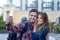 Happy couple of tourists taking selfie in showplace of city. Man and woman making photo on city background Royalty Free Stock Photo