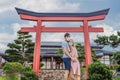 Happy couple travelers in medical mask looking at the Japanese traditional building. Tourists travel in Japan after the