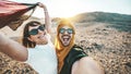 Happy couple of travelers taking selfie picture in rocky desert - Young man and woman having fun on summer vacation Royalty Free Stock Photo