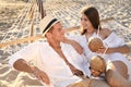 Happy couple with tropical cocktails relaxing in hammock on beach Royalty Free Stock Photo