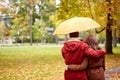 Happy couple with umbrella walking in autumn park Royalty Free Stock Photo