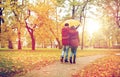 Happy couple with umbrella walking in autumn park Royalty Free Stock Photo