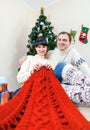 Happy couple under christmas tree with knitting work