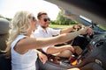 Happy couple using gps navigator in cabriolet car Royalty Free Stock Photo