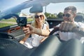 Happy couple using gps navigator in cabriolet car Royalty Free Stock Photo