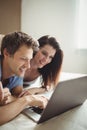 Happy couple using laptop on bed Royalty Free Stock Photo