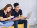 Happy couple using a laptop, calculating bills, mortgage or loan documents, family planning budget, managing household expenses. Royalty Free Stock Photo