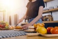 Happy couple using laptop computer preparing healthy food diet vegetable salad at home together. Woman and man are searching Royalty Free Stock Photo