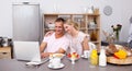 Happy couple using a laptop while having breakfast Royalty Free Stock Photo