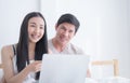 Happy couple is using laptop on morning bed with smile Royalty Free Stock Photo