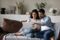 Happy young couple using laptop, relaxing sitting on couch together Royalty Free Stock Photo